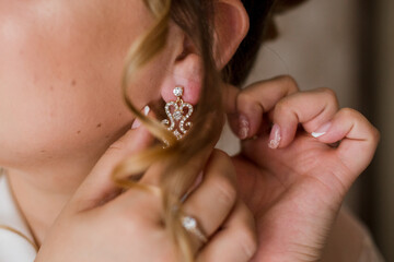 bride puts earrings on ear