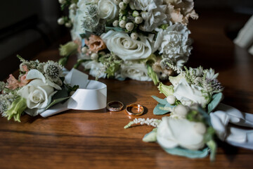 gold wedding rings near the bride's bouquet