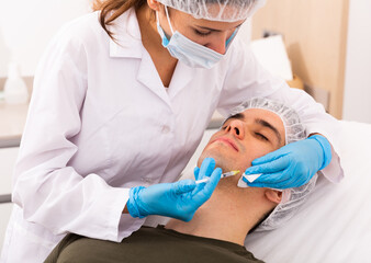 Man getting face injections at aesthetic clinic