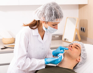 Man getting face injections at aesthetic clinic