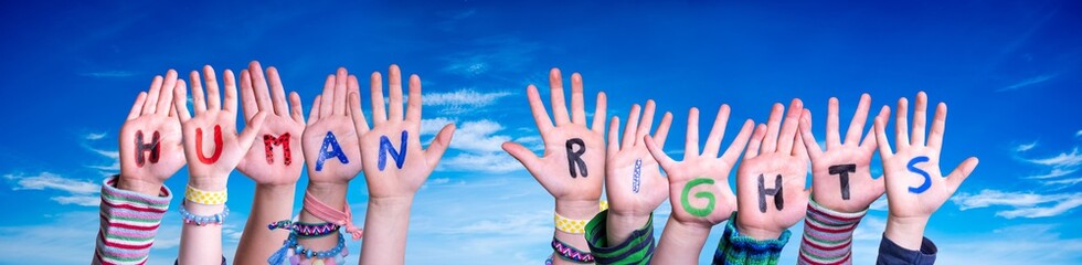 Children Hands Building Colorful English Word Human Rights. Blue Sky As Background