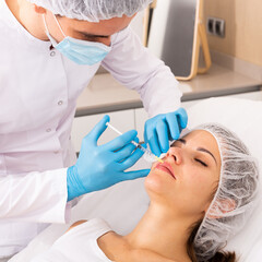 Naklejka premium Woman receiving rejuvenating facial injections
