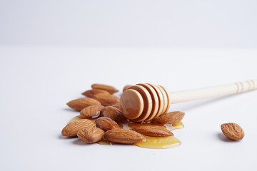 Honey and almond nuts or "badam" isolation on white background. Concept for super food, Healthy Snacks and sunnah food,
