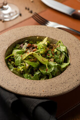 caesar salad with caramelized nuts bacon on a ceramic bowl