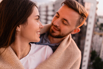 Close up portrait, man and woman smiling to each other on sunset with city in background. Couple romantic intimate moments