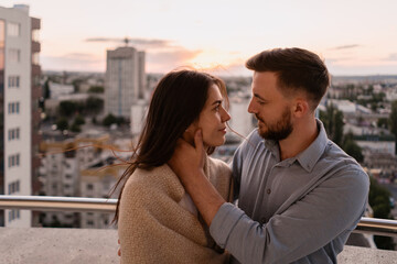 Obraz premium Close up portrait, man and woman smiling to each other on sunset with city in background. Couple romantic intimate moments