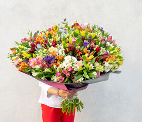 Colorful flower bouqet arrangement. Summer flowers held by florist in hand close up. Flowers for wedding and happy occasions.