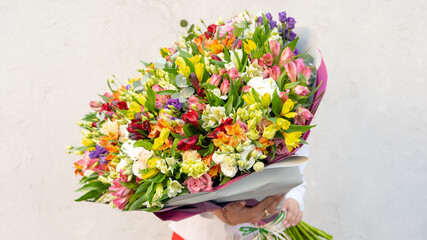 Colorful flower bouqet arrangement. Summer flowers held by florist in hand close up. Flowers for wedding and happy occasions.
