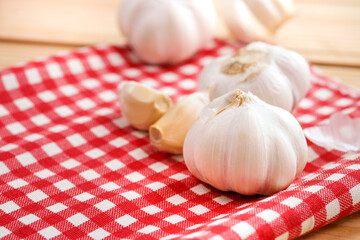 Garlic bulb head and cloves on chess fabric cloth, Herbs and spices are important in cooking.