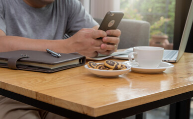 A young businessman sitting at a computer desk, Work from home and social concept.
