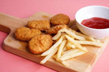 Naklejka premium Nugget, french fries plating on wood chopping board 