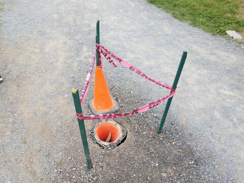 Hole With Orange Cones And Red Danger Tape