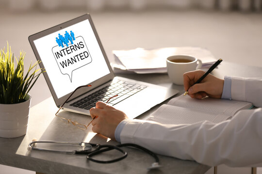 Doctor with laptop at table in office, closeup. Interns wanted