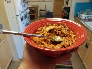 red bowl with pork and barbecue sauce in kitchen