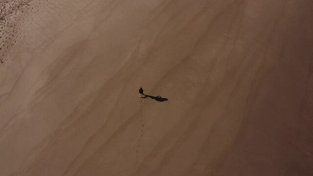 Woman walking alone living footsteps on a empty beach