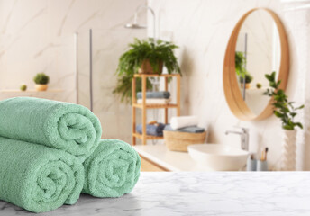 Fresh towels on marble table in bathroom. Space for text