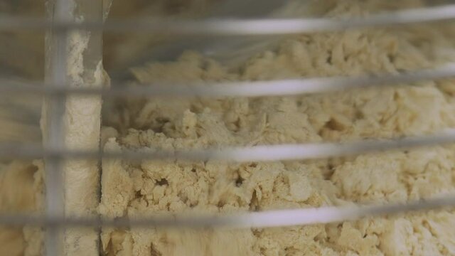 Industrial food production. Large scale ingredients mixer making a dough.