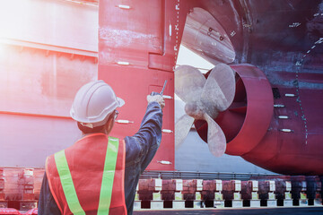 Shipyard ship repair worker with Talkie hand holding for shafting port controller, surveyor,...