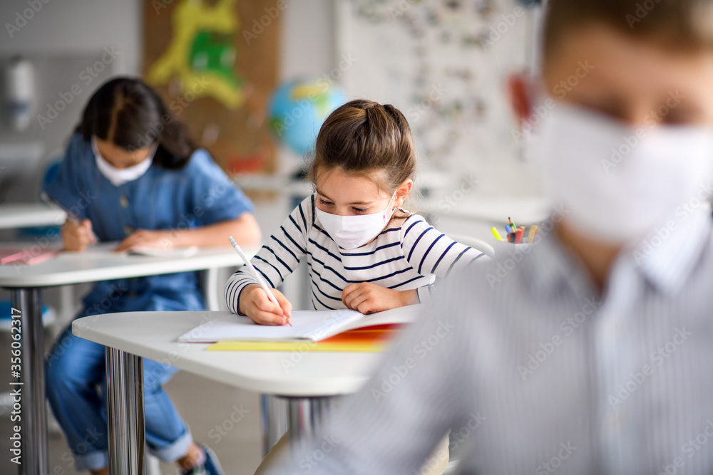 Wall mural Children with face mask back at school after covid-19 quarantine and lockdown.