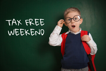 Little boy with backpack and text TAX FREE WEEKEND written on chalkboard