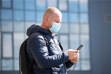 Tourist man in a medical surgical mask in the city.