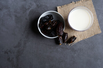Dates milk and dates in the bowl on grey background.
