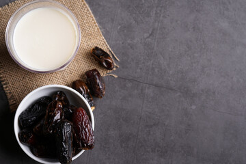 Dates milk and dates in the bowl on grey background.
