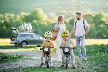 Family with two small children going on cycling trip in countryside.