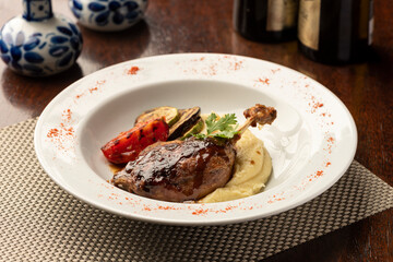 duck leg plate food with mashed potatoes and vegetables with blurred background