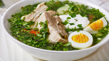 Delicious sorrel soup with boiled eggs on a bowl