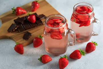 Strawberry drink with berries and wooden board with chocolate. Diet drink