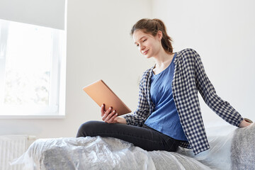 Frau mit Tablet Computer in der neuen Wohnung