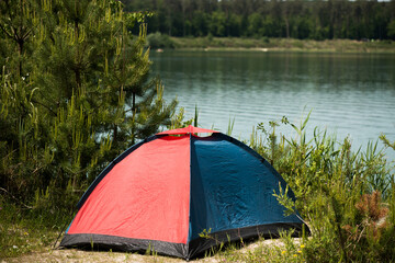 Tent for hiking by the lake in the woods.