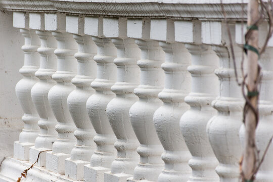 Pattern of white balusters. Architectural elements of stairs and railings. Beautiful repeating pattern. The classic elements of the exterior. Abstract background of architectural elements.