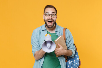 Shocked young man student in casual clothes glasses backpack hold books isolated on yellow background. Education in high school university college concept. Mock up copy space. Scream in megaphone.