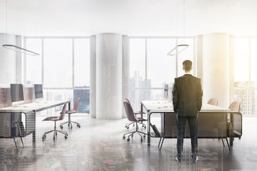 Young businessman standing in modern office interior