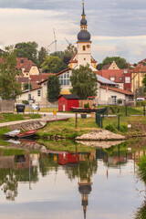 Fototapeta na wymiar Mainstockheim am Main mit Fähre und Kirche mit Spiegelung im Fluß