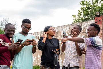 a group of young africans using their phones, hanging out together, students leisure on campus, conversation