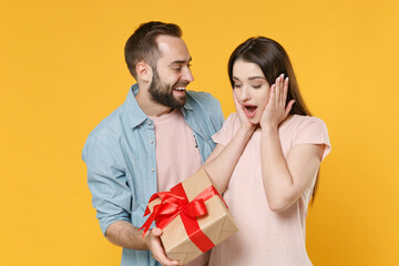 Shocked couple two friends guy girl in casual clothes isolated on yellow background. Valentine's...