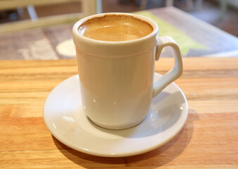 Closeup a cup of hot espresso coffee on wooden table