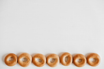 Drying or mini round bagels on a white wooden background. Copy, empty space for text