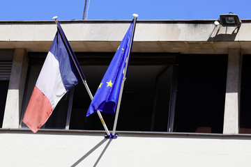 french and EU European Union flags on window of city hall