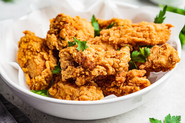 Crispy fried chicken in a white bowl.