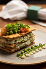 puff pastry stuffed with pea cream and garnished with salmon tomato and basil