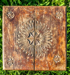 The top of an old wooden stool with hand-carved close - up on a background of green grass