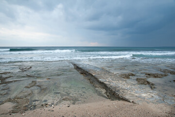 Bridge from the rocky shore to the sea.