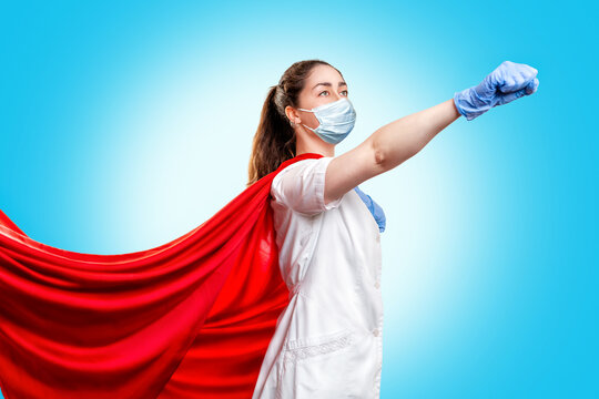 A Doctor Or Nurse In Medical Gloves, A Surgical Mask And A Red Superhero Cape On A Blue Background, Rushes To Help. The Concept Of A Super Hero Power For Clinics And Hospitals. Copy Space