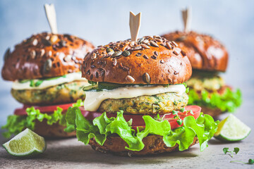Vegan falafel burger with vegetables and sauce, dark background. Healthy  plant based food concept.