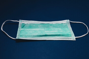 Medical surgical mask on blue paper background, Prevent Covid-19, protection factor for virus. Dark...