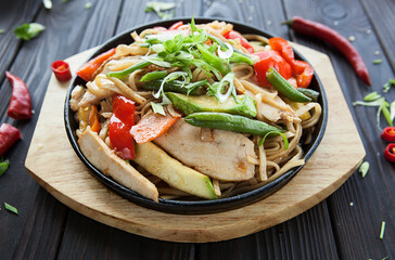 Asian noodles with white meat and vegetables, a bright Asian dish in a pan.
traditional asian food.